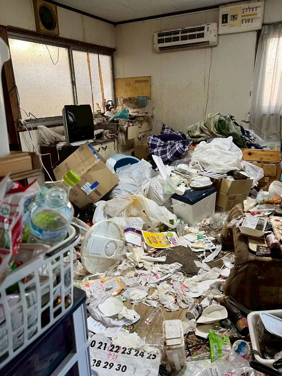 宮崎市のゴミ屋敷片付け前、袋や容器などがたまった室内